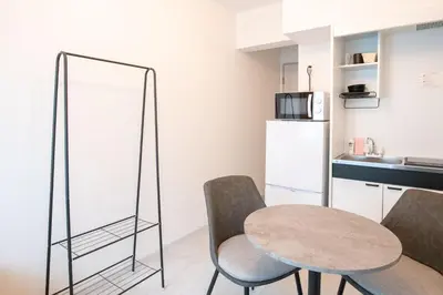 a kitchen with a table and chairs and a mirror at \u58a8\u7530Dias in Tokyo