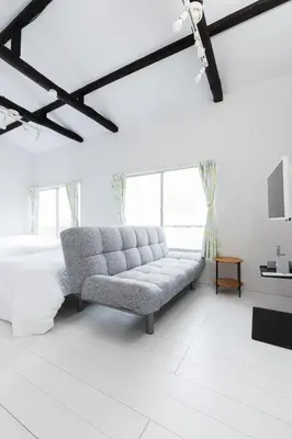 a white living room with a couch and a bed at Sola Stay Kanegafuchi in Tokyo