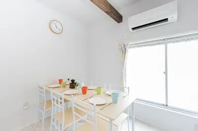 a dining room with a table and chairs and a clock at Sola Stay Kanegafuchi in Tokyo