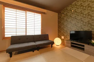 a living room with a couch and a flat screen tv at Asagaya House by Tranova in Tokyo