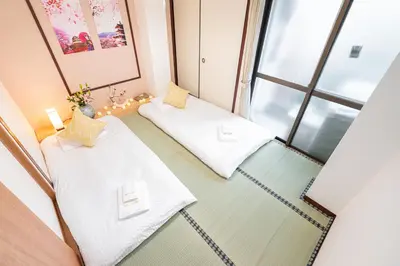 two beds in a room with a window at NEW OPEN! Nearest JR Shinokubo and JR soubu line HIgashinakano, shinjuku 5 minute ginza 25 minute asakusa 35 minute in Tokyo