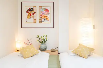 two beds in a room with a picture on the wall at NEW OPEN! Nearest JR Shinokubo and JR soubu line HIgashinakano, shinjuku 5 minute ginza 25 minute asakusa 35 minute in Tokyo