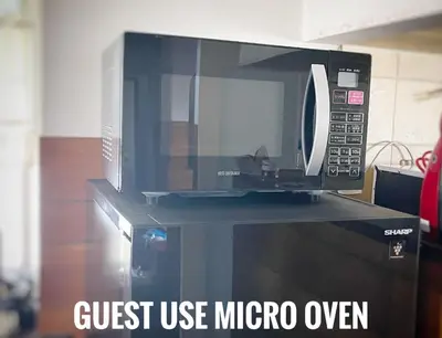 a microwave sitting on top of a microwave oven at Tatami room & Living Room equipped with Multinational TV and Fire, BBQ corner in Tokyo Downtown House in Tokyo