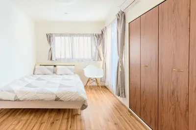 a bedroom with a bed and a wooden cabinet at 駒込駅徒歩7分/旧古河庭園至近(100m)の4LDKマンション「92m2」 in Tokyo
