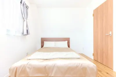 a bed in a white room with a window at 駒込駅徒歩7分/旧古河庭園至近(100m)の4LDKマンション「92m2」 in Tokyo