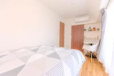 a white bedroom with a bed and a chair at 駒込駅徒歩7分/旧古河庭園至近(100m)の4LDKマンション「92m2」 in Tokyo