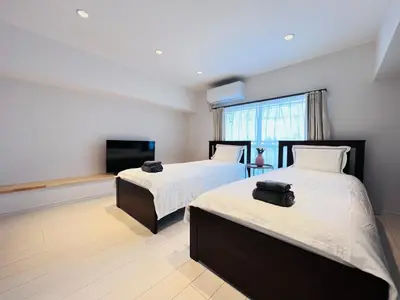 a bedroom with two beds and a flat screen tv at shinjuku Jun7F-SJ0095 in Tokyo