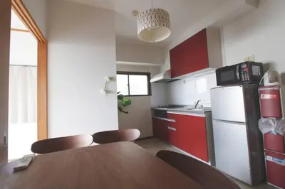 a kitchen with a wooden table and red cabinets at \u7834\u68c4\u30ea\u30b9\u30c6\u30a3\u30f3\u30b0 in Tokyo