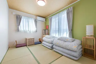 a bedroom with a bed and a large window at Ici Japon Village in Tokyo