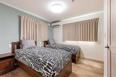 a small room with two beds and a window at Ici Japon Village in Tokyo