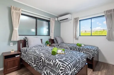 a bedroom with two beds and a window at Ici Japon Village in Tokyo