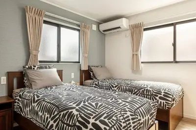 two beds in a room with windows at Ici Japon Village in Tokyo