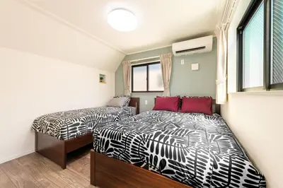 a bedroom with two beds and a window at Ici Japon Village in Tokyo