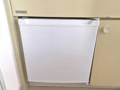 a white refrigerator in a kitchen with its door open at DP House in Tokyo