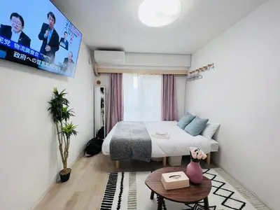 a bedroom with a bed and a tv on the wall at Shinjuku HM hotel-SJ0016 in Tokyo