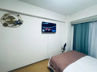 a bedroom with a bed and a tv on the wall at Shinjuku HM hotel-SJ0016 in Tokyo