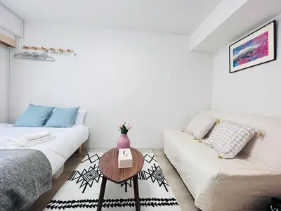a living room with two beds and a table at Shinjuku HM hotel-SJ0016 in Tokyo