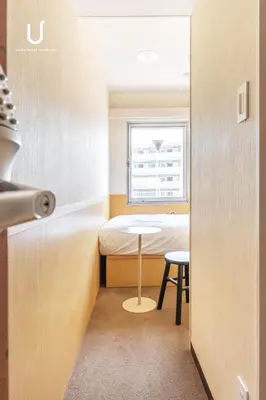 a small room with a bed and a table at Hotel Residence Ohashi Kaikan Tokyo Shibuya in Tokyo