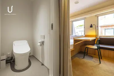 a bathroom with a toilet and a sink and a window at Hotel Residence Ohashi Kaikan Tokyo Shibuya in Tokyo