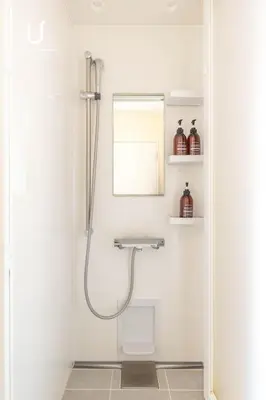 a shower in a white bathroom with a mirror at Hotel Residence Ohashi Kaikan Tokyo Shibuya in Tokyo