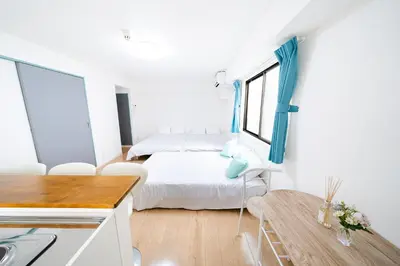 a white room with a bed and a table at SUA HOTEL Nishikasai in Tokyo