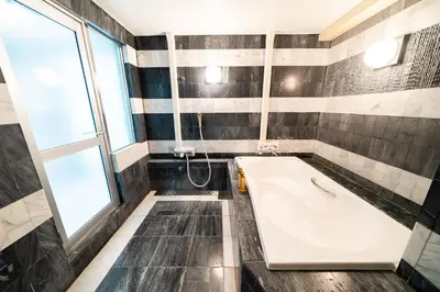 a bathroom with a tub and a window at SUA HOTEL Nishikasai in Tokyo