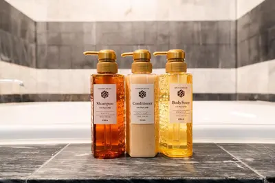 three bottles of soap sitting on a counter in a bathroom at SUA HOTEL Nishikasai in Tokyo
