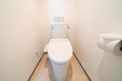 a white toilet in a bathroom with a toilet paper dispenser at SUA HOTEL Nishikasai in Tokyo