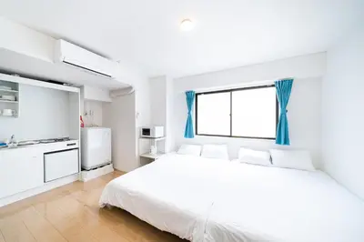 a white bedroom with a large bed and a window at SUA HOTEL Nishikasai in Tokyo