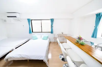 a small room with two beds and a table at SUA HOTEL Nishikasai in Tokyo