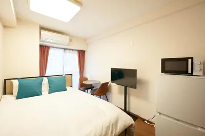 a hotel room with a bed and a flat screen tv at \u30ac\u30fc\u30c7\u30f3\u5927\u585a in Tokyo