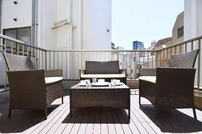a patio with chairs and a table on a balcony at TERRACE HOUSE Shibuya Maruyamacho - Vacation STAY 79338v in Tokyo