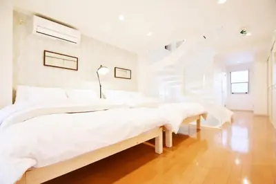 a white bedroom with two beds and a staircase at TERRACE HOUSE Shibuya Maruyamacho - Vacation STAY 79338v in Tokyo