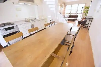 a large wooden table in a kitchen with chairs at TERRACE HOUSE Shibuya Maruyamacho - Vacation STAY 79338v in Tokyo