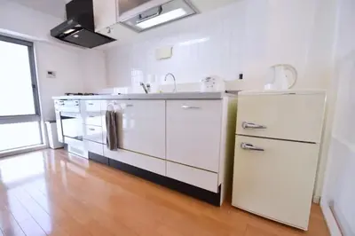 a kitchen with white appliances and a wooden floor at TERRACE HOUSE Shibuya Maruyamacho - Vacation STAY 79338v in Tokyo