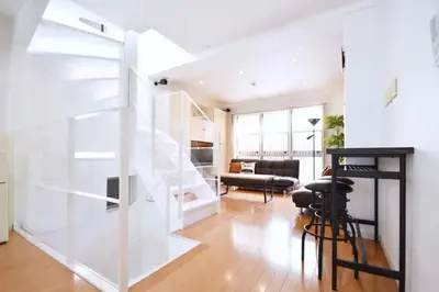 a living room with white walls and a staircase at TERRACE HOUSE Shibuya Maruyamacho - Vacation STAY 79338v in Tokyo