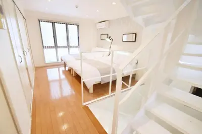a white bedroom with a bed and a staircase at TERRACE HOUSE Shibuya Maruyamacho - Vacation STAY 79338v in Tokyo