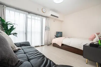 a bedroom with a bed and a couch in front of a window at \u65b0\u5bbf\u5340\u65b0\u5927\u4e45\u4fdd\u7ad9\u5f92\u6b653\u5206\u9418\u9ad8\u7d1a\u516c\u5bd3\u7dca\u9130\u97d3\u570b\u5ee3\u5834 in Tokyo