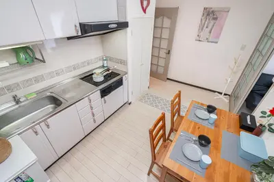 a small kitchen with a wooden table and chairs at \u65b0\u5bbf\u5340\u65b0\u5927\u4e45\u4fdd\u7ad9\u5f92\u6b653\u5206\u9418\u9ad8\u7d1a\u516c\u5bd3\u7dca\u9130\u97d3\u570b\u5ee3\u5834 in Tokyo