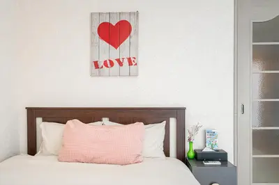 a bedroom with a bed with a red heart on the wall at \u65b0\u5bbf\u5340\u65b0\u5927\u4e45\u4fdd\u7ad9\u5f92\u6b653\u5206\u9418\u9ad8\u7d1a\u516c\u5bd3\u7dca\u9130\u97d3\u570b\u5ee3\u5834 in Tokyo