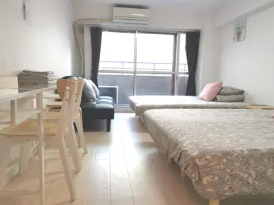 a bedroom with two beds and a desk and a couch at Lions Mansion Kabukicho No2 with2 bedroom in Tokyo