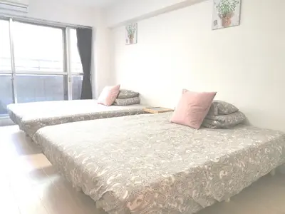 a bedroom with two beds with pink pillows at Lions Mansion Kabukicho No2 with2 bedroom in Tokyo