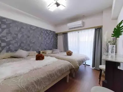 a bedroom with two beds and a large window at K Shinjuku area-MAX 4p-\u65b0\u5bbf\u4e2d\u5fc3\u5730\u57df-\u6b65\u884c\u53ef\u5230\u65b0\u5bbf\u5927\u4e45\u4fdd\u6b4c\u821e\u4f0e\u753a-\u53ef\u4f4f4\u4eba in Tokyo