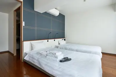 a bedroom with a white bed with shoes on it at TOKIO's HOTEL in Tokyo