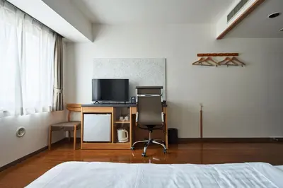 a bedroom with a bed and a desk with a television at TOKIO's HOTEL in Tokyo