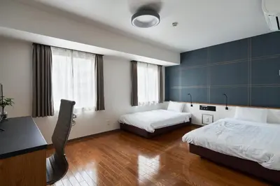 a hotel room with two beds and a desk at TOKIO's HOTEL in Tokyo