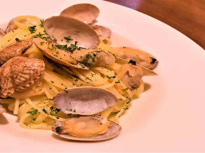 a plate of pasta with shrimp and mushrooms at KOKO HOTEL Shinjuku Yotsuya- formerly Hotel Wing International Premium Tokyo Yotsuya in Tokyo