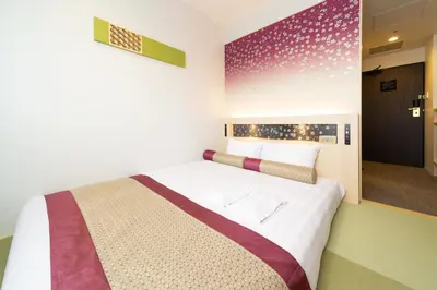 a bedroom with a bed and a large mirror at KOKO HOTEL Shinjuku Yotsuya- formerly Hotel Wing International Premium Tokyo Yotsuya in Tokyo