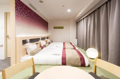 a hotel room with two beds and a table at KOKO HOTEL Shinjuku Yotsuya- formerly Hotel Wing International Premium Tokyo Yotsuya in Tokyo
