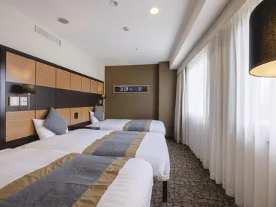 a hotel room with two beds and a window at KOKO HOTEL Shinjuku Yotsuya- formerly Hotel Wing International Premium Tokyo Yotsuya in Tokyo